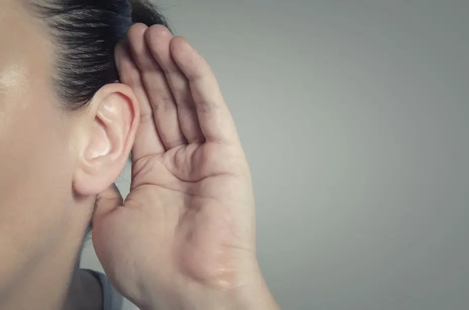 Mulher com a mão no ouvido ouvindo o som silencioso ou prestando atenção