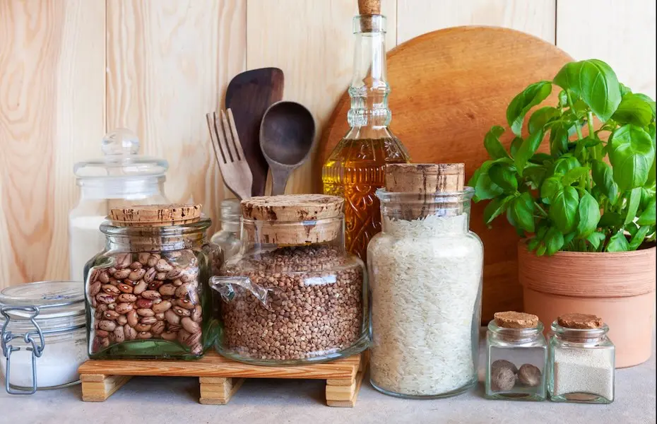 Potes de cereais, utensílios de cozinha e plantas caseiras. Ambientes saudáveis, cozinha confortável, conceito de estilo de vida sustentável.