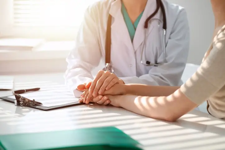 Médico tranquilizando paciente mulher enquanto está sentado na mesa na clínica, apenas as mãos. Medicina e melhor conceito de serviço