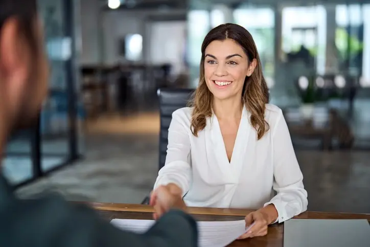 Mulher de negócios madura sorridente apertando as mãos de RH contratando um recruta em uma entrevista de emprego.